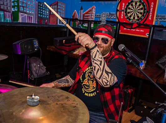 Close up of Joe Saad of Smoove Series dressed for Halloween show pounding the drums at The Blind Rhino in South Norwalk, CT